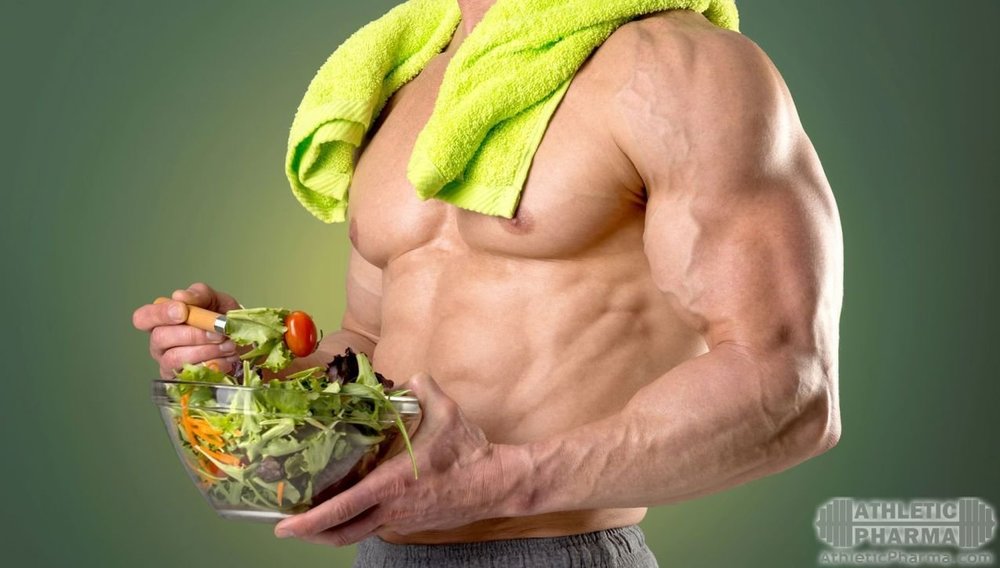 Спортивный парень ест овощной салат