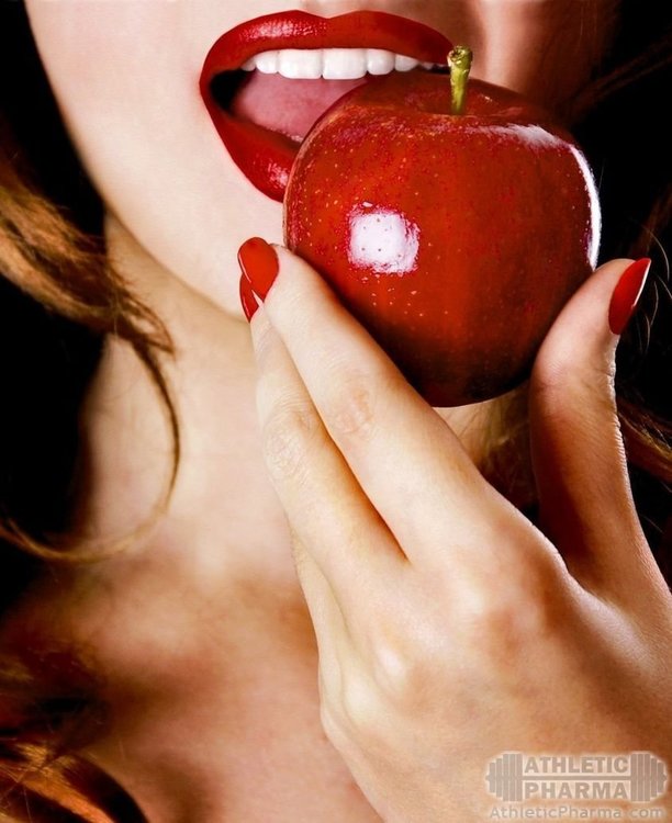 Девушка сексуально кусает яблоко